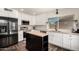 Modern kitchen with white cabinets, stainless steel appliances, marble countertops, and black island at 1353 W Kiowa Ave, Mesa, AZ 85202