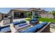 Backyard featuring outdoor seating with fire pit, grill, travertine patio, and artificial turf at 15276 W Latham St, Goodyear, AZ 85338