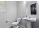 The half bath features a pedestal sink, a toilet, a large mirror, and a modern faucet for convenience at 15276 W Latham St, Goodyear, AZ 85338