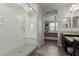 Bathroom featuring glass shower with bench, dark vanity with granite countertop, and bedroom view at 15276 W Latham St, Goodyear, AZ 85338