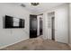 Bedroom features a mounted TV, a closet with a shelving unit, neutral walls, and a fan for comfort at 15276 W Latham St, Goodyear, AZ 85338