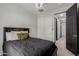 Bright bedroom features a queen-size bed, a closet, and neutral-toned carpet and paint, creating a cozy and inviting space at 15276 W Latham St, Goodyear, AZ 85338