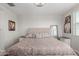 Well-lit bedroom with carpet, tufted headboard, and neutral wall color at 15276 W Latham St, Goodyear, AZ 85338