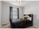 Bedroom features a large window with privacy blinds, dark gray curtains, a queen-size bed, and neutral walls at 15276 W Latham St, Goodyear, AZ 85338