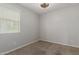 Bright bedroom boasts a ceiling fan, window with blinds, neutral paint, plush carpet, and ample outlets at 15276 W Latham St, Goodyear, AZ 85338