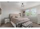 Primary bedroom with neutral tones, tufted headboard, and natural light from two windows at 15276 W Latham St, Goodyear, AZ 85338