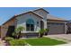 Charming single-story home featuring a tile roof, arched window, desert landscaping and a brick driveway at 15276 W Latham St, Goodyear, AZ 85338