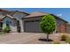 Attractive single-story home with tile roof, brick driveway, manicured landscaping and attached garage at 15276 W Latham St, Goodyear, AZ 85338