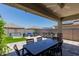 Inviting outdoor patio featuring a dining table, BBQ bar, seating area, and landscaped greenery with a tranquil water feature at 15276 W Latham St, Goodyear, AZ 85338