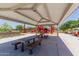 Covered picnic area featuring tables and benches adjacent to a playground, perfect for Gathering gatherings and outdoor dining at 15276 W Latham St, Goodyear, AZ 85338