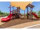 A colorful community playground featuring slides, climbing structures, and shade canopies for a safe play environment at 15276 W Latham St, Goodyear, AZ 85338