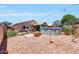 The backyard with a pool, covered patio, and a well-manicured landscape is great for outdoor activities at 15505 N 135Th Dr, Surprise, AZ 85374