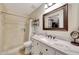 Bathroom featuring tiled walls, a framed mirror, a single sink vanity, and a walk-in closet at 15505 N 135Th Dr, Surprise, AZ 85374
