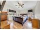 Comfortable bedroom featuring hardwood floors, a ceiling fan, a TV, and large windows with stylish curtains at 15505 N 135Th Dr, Surprise, AZ 85374