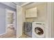 A fully equipped laundry room conveniently located near the bathroom with modern appliances and ample storage space at 15505 N 135Th Dr, Surprise, AZ 85374
