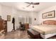 Bedroom features a ceiling fan, hardwood floor, a desk, and a comfortable bed with natural lighting at 17108 N Estrella Vista Dr, Surprise, AZ 85374