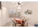 A cozy dining area with bright light from the large windows and a ceiling fan for comfortable living at 17108 N Estrella Vista Dr, Surprise, AZ 85374