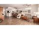 Open-concept living room with laminate floors, ceiling fans, bright natural light, and access to the kitchen at 17108 N Estrella Vista Dr, Surprise, AZ 85374