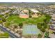 Aerial view showing tennis courts, baseball fields, and grassy areas surrounded by homes and a school at 17652 W Fetlock Trl, Surprise, AZ 85387