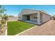 A home's backyard features a small patch of grass and low maintenance landscaping at 17652 W Fetlock Trl, Surprise, AZ 85387