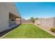 A backyard featuring a manicured lawn, concrete patio, and block wall at 17652 W Fetlock Trl, Surprise, AZ 85387