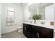 A modern bathroom featuring a double sink vanity and a decorative vase with flowers at 17652 W Fetlock Trl, Surprise, AZ 85387