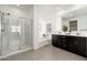 Modern bathroom featuring a glass shower, double sinks, and a separate tub at 17652 W Fetlock Trl, Surprise, AZ 85387
