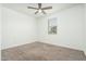 A cozy bedroom with neutral carpet and a ceiling fan with light fixture at 17652 W Fetlock Trl, Surprise, AZ 85387