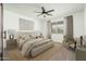 Stylishly furnished bedroom with a ceiling fan, neutral decor, and natural light at 17652 W Fetlock Trl, Surprise, AZ 85387