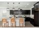 Modern kitchen features dark cabinets, granite counters, stainless steel appliances and an island with seating at 17652 W Fetlock Trl, Surprise, AZ 85387