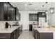 Modern kitchen with dark cabinets, granite countertops, stainless steel appliances and subway tile backsplash at 17652 W Fetlock Trl, Surprise, AZ 85387