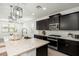Modern kitchen with dark cabinets, granite countertops, stainless steel appliances and pendant lighting at 17652 W Fetlock Trl, Surprise, AZ 85387