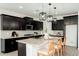 Modern kitchen features dark cabinets, granite counters, stainless steel appliances and an island with seating at 17652 W Fetlock Trl, Surprise, AZ 85387