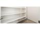 Well-lit pantry featuring ample white shelving for optimal storage space at 17652 W Fetlock Trl, Surprise, AZ 85387