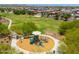 Aerial view of a playground with multiple slides and play equipment, surrounded by walkways and landscaping at 17652 W Fetlock Trl, Surprise, AZ 85387