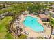 Aerial view of a community pool surrounded by palm trees and lounge chairs at 17652 W Fetlock Trl, Surprise, AZ 85387