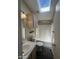 Bright bathroom with a skylight, shower-tub combo, wood-look flooring, and vanity storage at 18026 N Cave Creek Rd # 140, Phoenix, AZ 85032