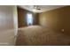 Large bedroom with tan carpet, a ceiling fan, and a sunlit window with neutral curtains at 18026 N Cave Creek Rd # 140, Phoenix, AZ 85032
