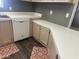 Cozy kitchen with wood flooring, ample cabinet space, a white dishwasher, and light countertops at 18026 N Cave Creek Rd # 140, Phoenix, AZ 85032