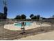 Outdoor community pool is fenced for safety and surrounded by lounge seating at 18026 N Cave Creek Rd # 140, Phoenix, AZ 85032