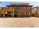 Rear exterior of a two story home showcasing a covered patio, large gravel backyard, and solar panels on the roof at 2030 W Whisper Rock Trl, Phoenix, AZ 85085