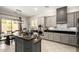 Stylish kitchen features stainless steel appliances, gray cabinets, an island with seating, and open dining area at 2030 W Whisper Rock Trl, Phoenix, AZ 85085