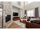 Bright living room with stone fireplace, high ceilings, and comfortable leather seating at 2030 W Whisper Rock Trl, Phoenix, AZ 85085