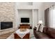 Inviting living room featuring a cozy fireplace, entertainment center, and comfortable leather sofa at 2030 W Whisper Rock Trl, Phoenix, AZ 85085