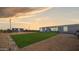 Spacious backyard with gravel, artificial turf, and a storage shed at sunset at 2242 E 12Th Ave, Apache Junction, AZ 85119