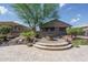 Beautiful backyard featuring desert landscaping, a stone fire pit, and a spacious patio area at 22574 W Moonlight Path, Buckeye, AZ 85326
