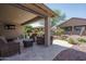 Relaxing covered patio featuring stylish wicker seating, a ceiling fan, and landscaped surroundings at 22574 W Moonlight Path, Buckeye, AZ 85326
