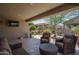 Enjoy outdoor living on this spacious covered patio with comfortable seating, a TV, and lush landscaping at 22574 W Moonlight Path, Buckeye, AZ 85326