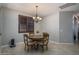 Cozy dining area with a round table set, chandelier lighting, and tiled floors at 22574 W Moonlight Path, Buckeye, AZ 85326