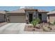 Charming single-story home featuring a tile roof, two-car garage, and beautiful desert landscaping at 22574 W Moonlight Path, Buckeye, AZ 85326